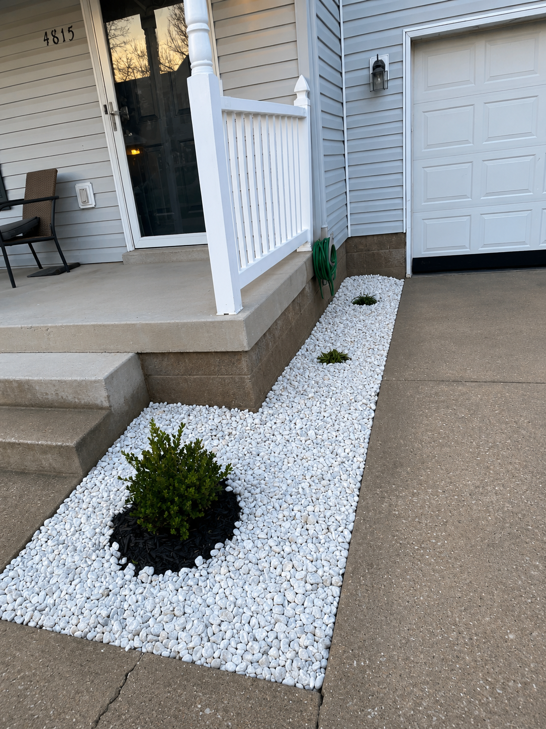 White rock landscape bed with boxwood accent